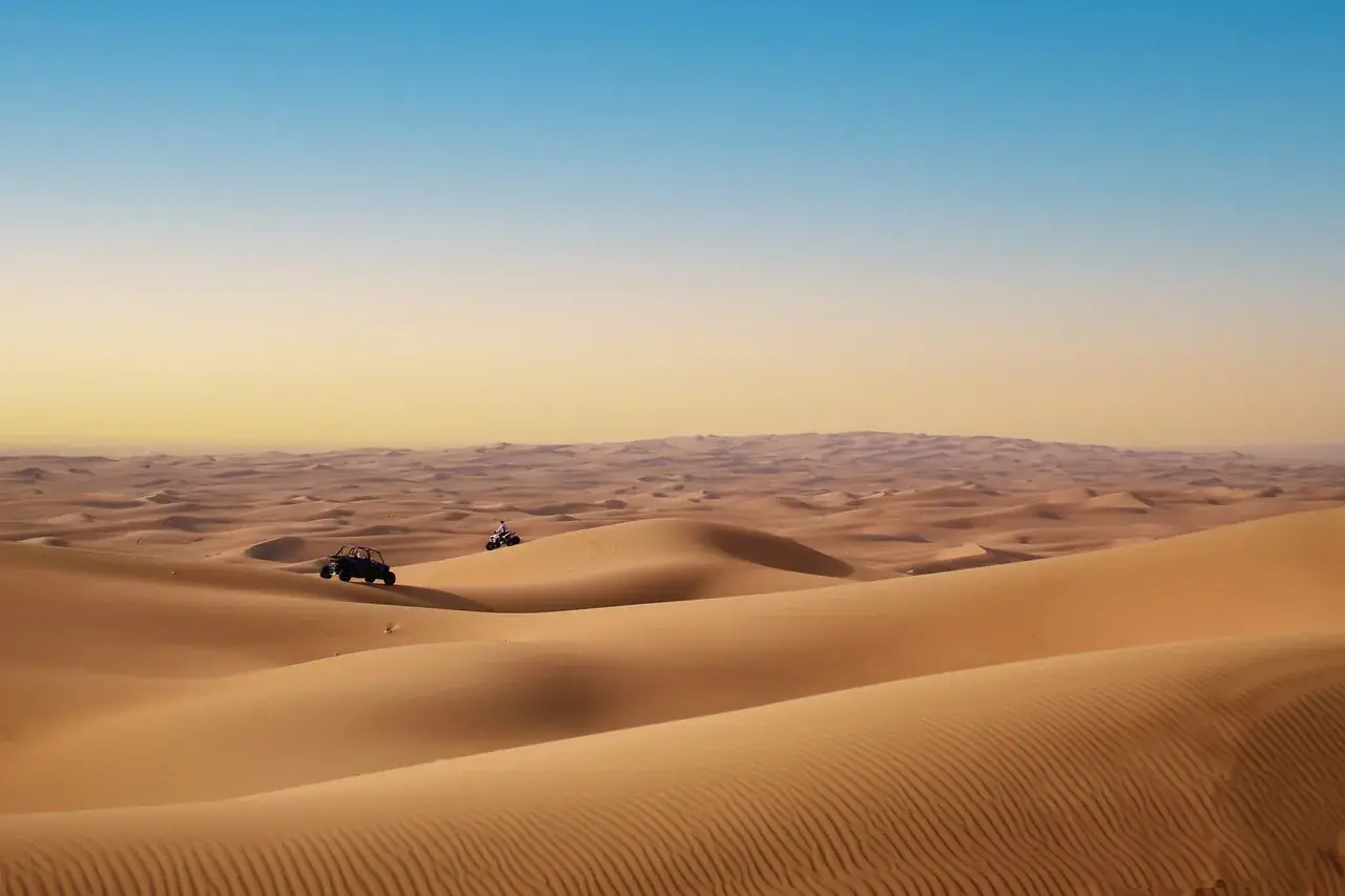 Buggies crossing wide open desert dunes
