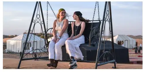 Guests on the swing at the edge of the Merzouga Glamping camp