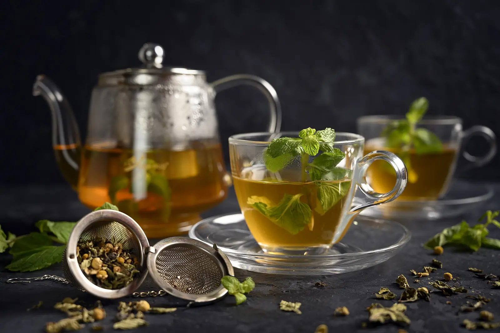 Tetera de cristal y vasos de té a la menta marroquí recién preparado