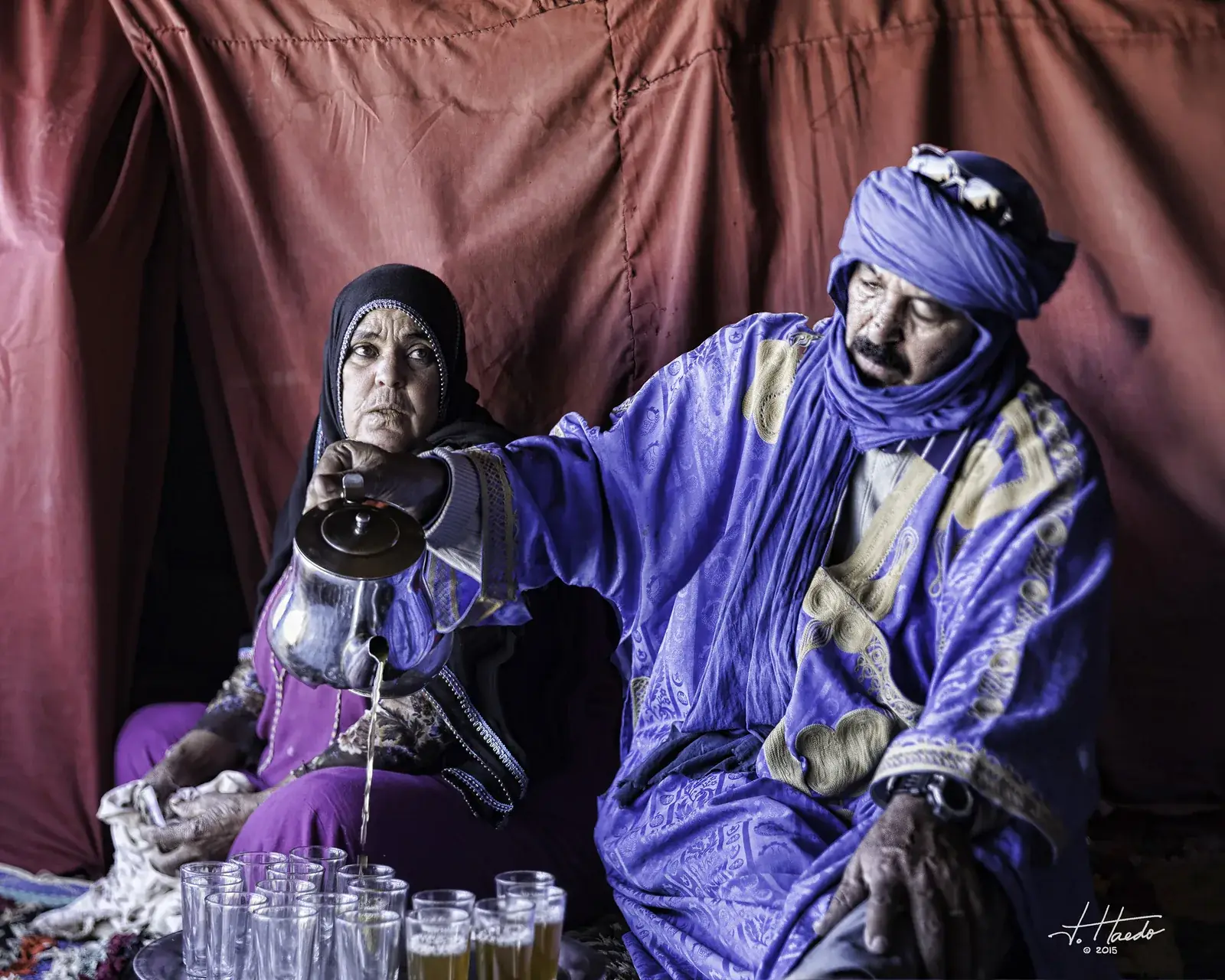 A nomad family pouring mint tea inside their desert tent