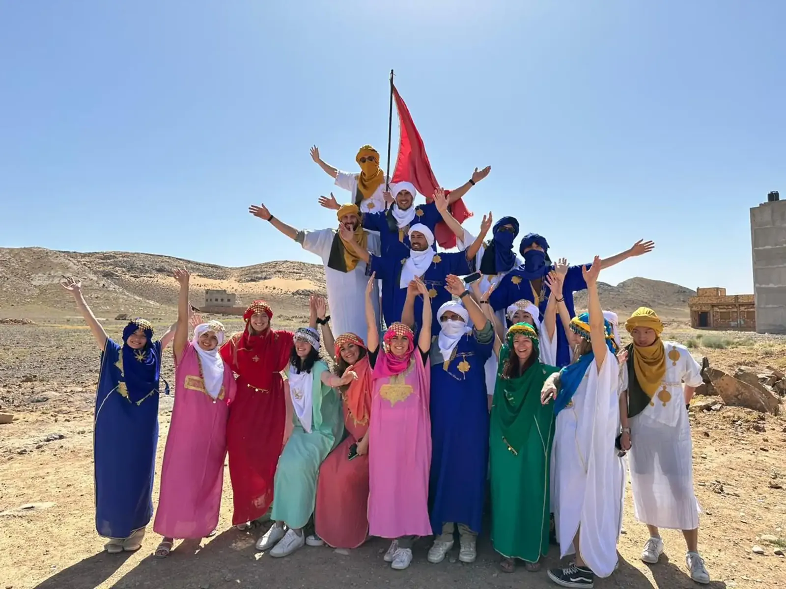 Travel group posing together in colourful robes during a sightseeing stop