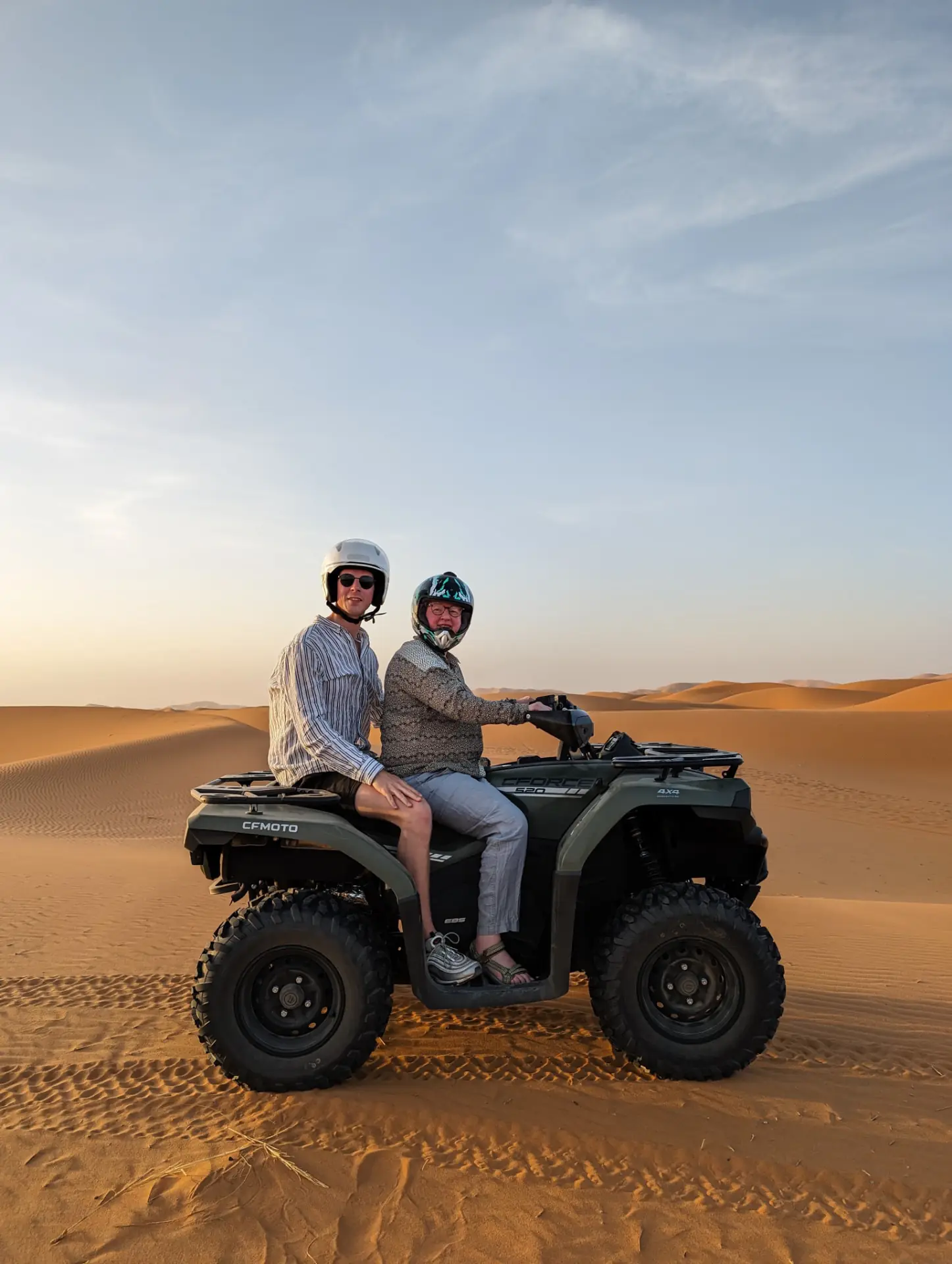Couple on a quad bike at sunset in the Merzouga desert