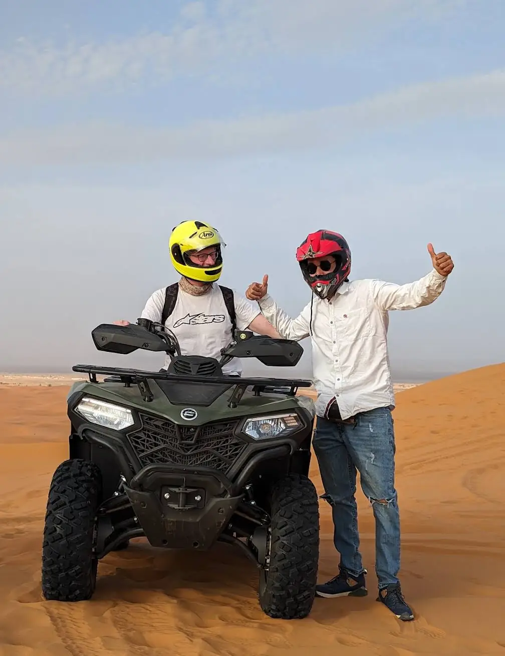 Guide and guest giving thumbs up beside a quad bike