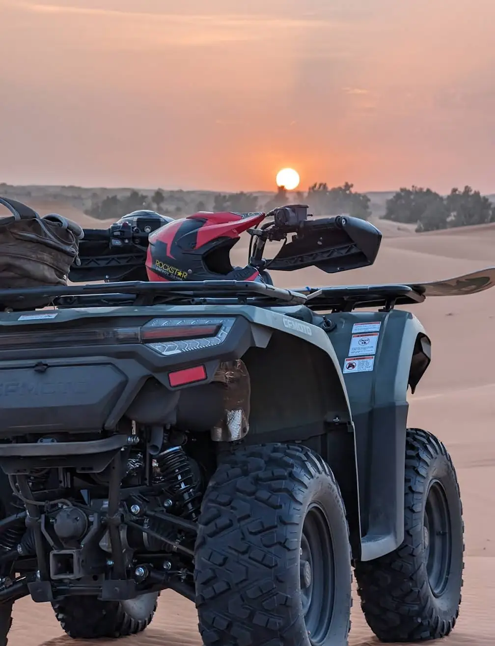 Quad bike parked on the dunes at sunset