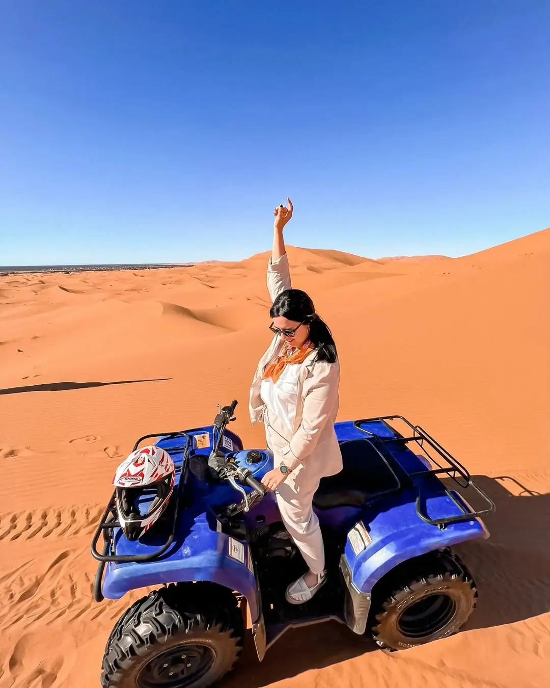 Guest standing beside a quad bike on the Erg Chebbi dunes