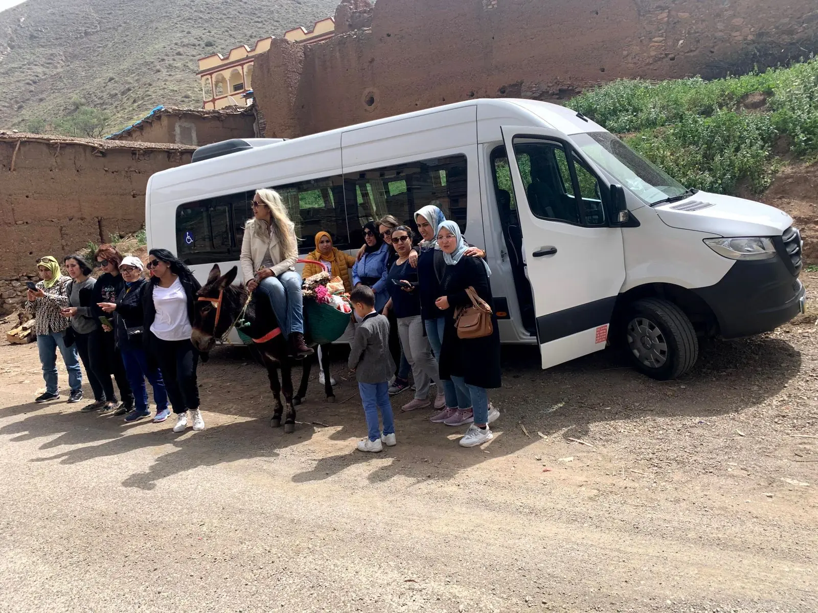 A group of travellers standing beside a transfer minibus