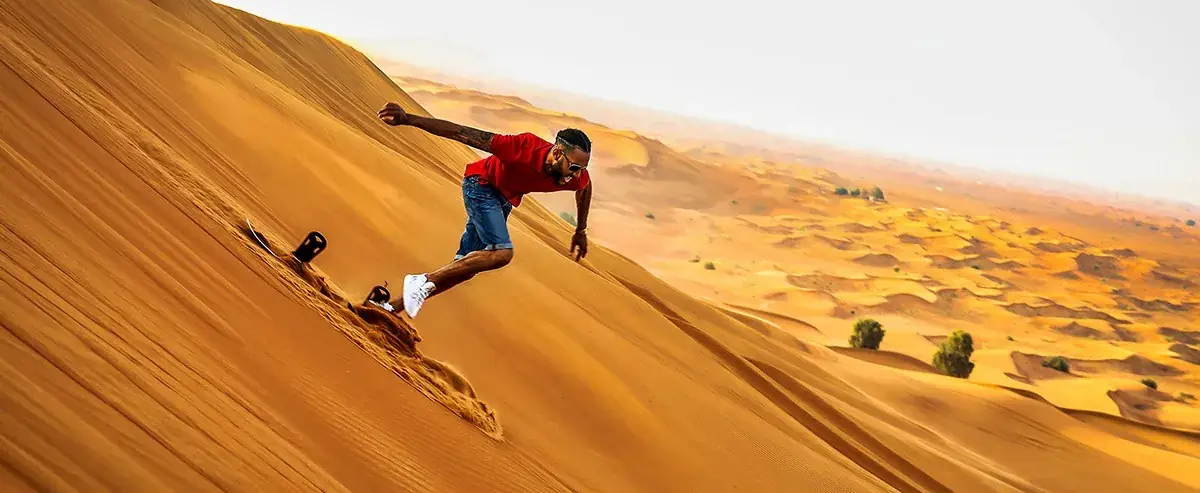 Wide view of guests sandboarding on Erg Chebbi