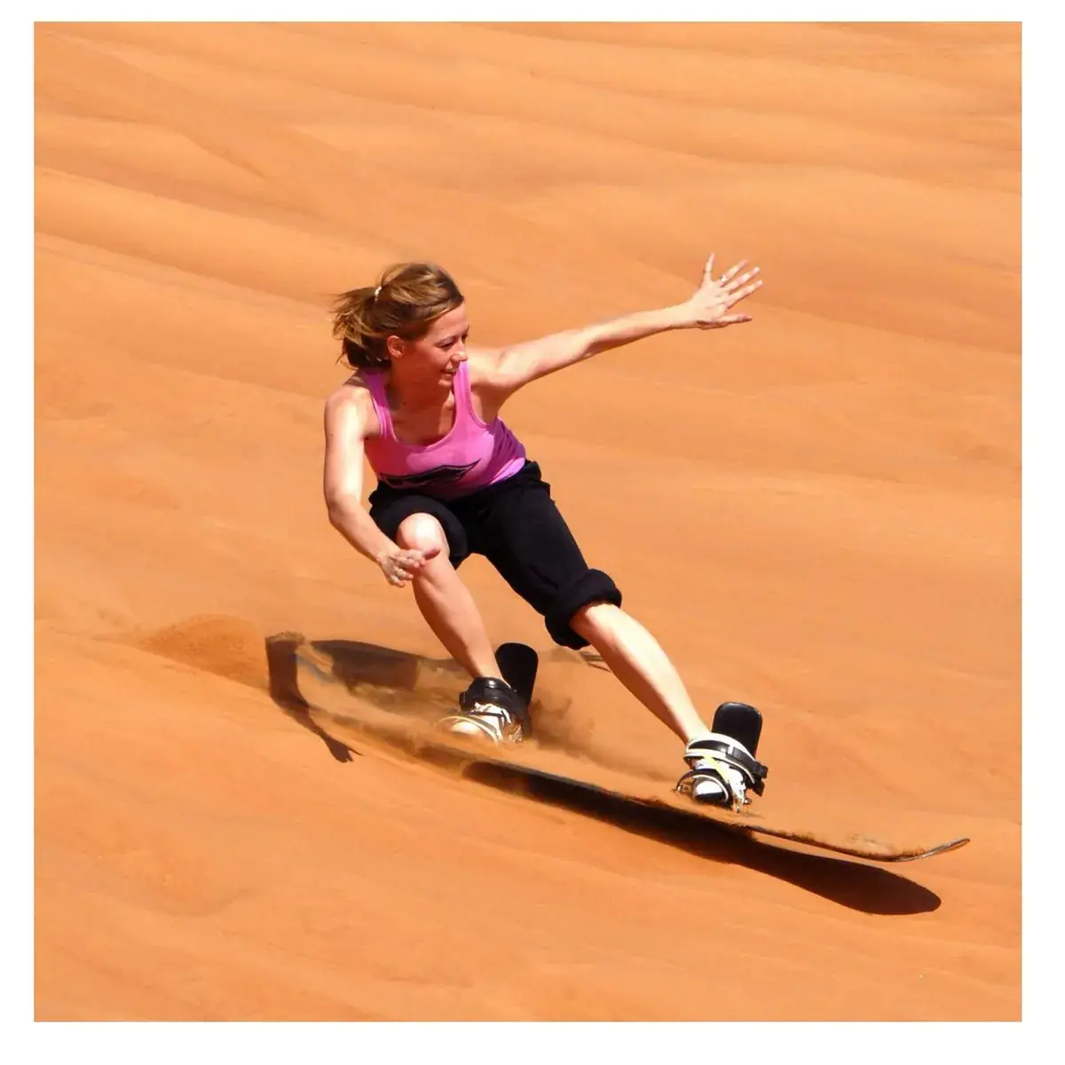 Woman sandboarding in the Merzouga desert