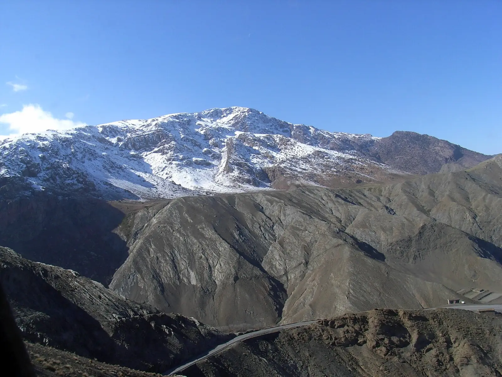 La carretera N9 serpenteando bajo los picos nevados del Alto Atlas en la ruta desde Marrakech