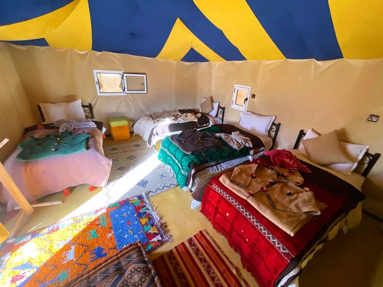 Family tent at Merzouga Glamping with four beds, rugs and traditional blankets
