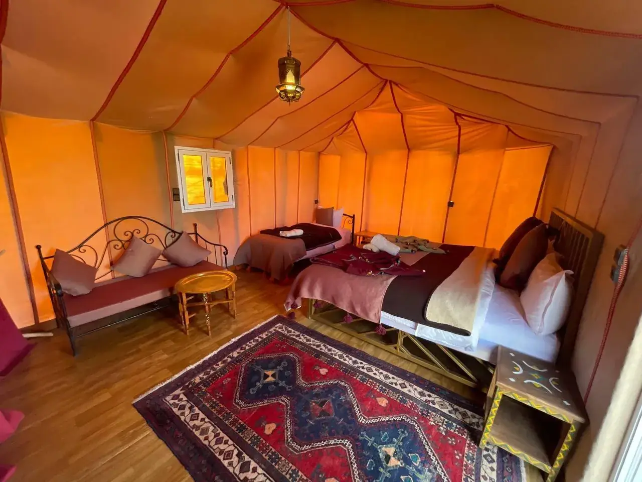 Triple luxury tent at Merzouga Glamping with three beds and traditional Moroccan textiles